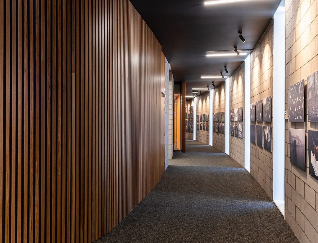 Image shows the interior walkway with photographs on the wall of the energy efficient commercial building the National Jewish Memorial centre.