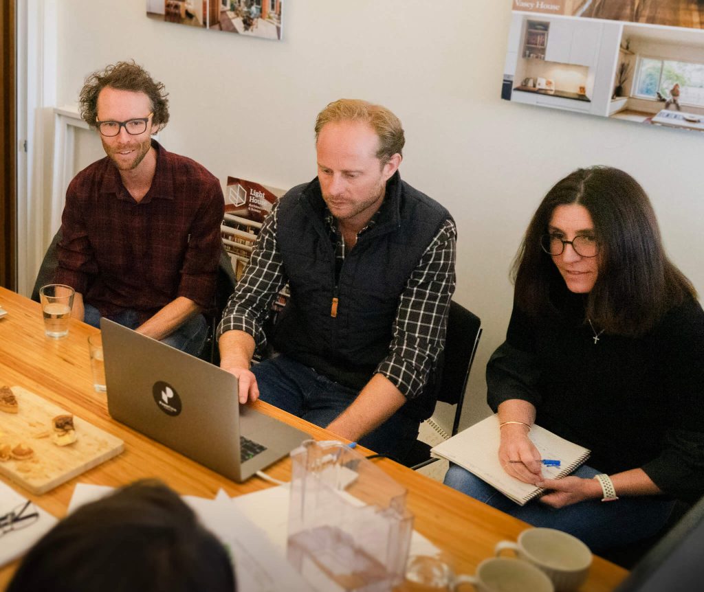 Powerhaus Engineering team of Matt Godfrey, Andrew Pickard and Lisa Lockey, sitting at a table smilling.