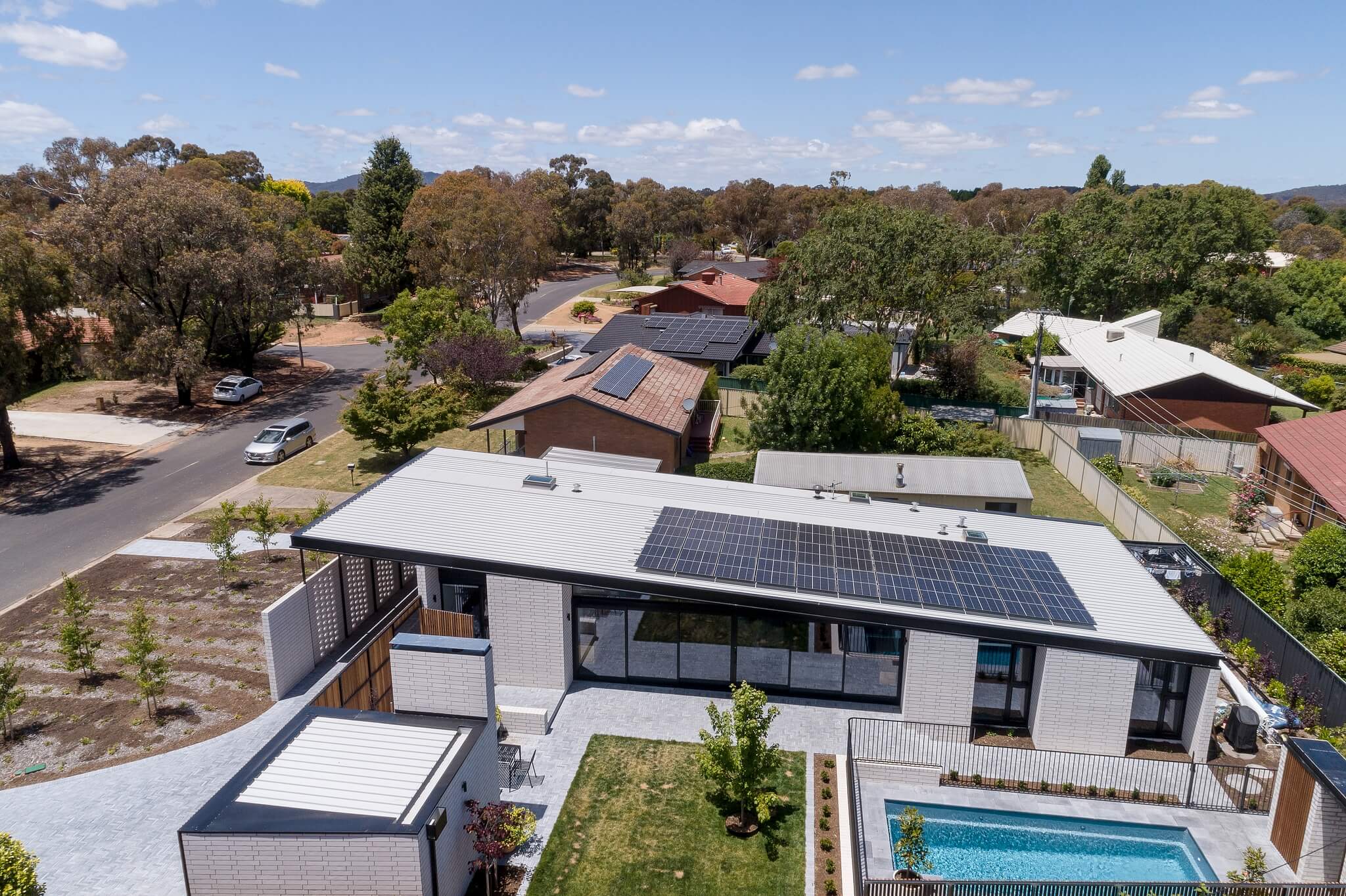Arial view of Ben Walker Architect's energy efficient Kaleen House, showing north facade with large glass doors and pool.