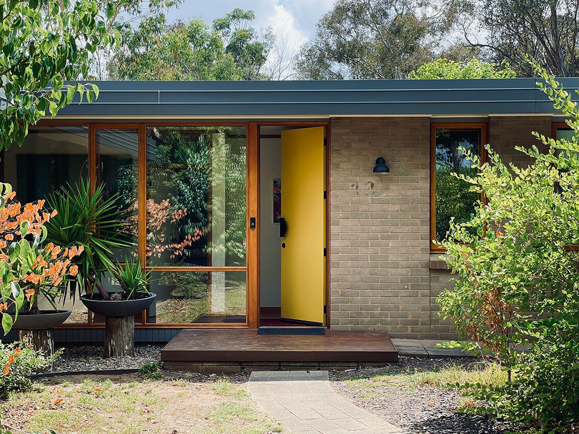 Image of the yellow front door and windows of the 6 star home architecturally updated by the Mill Architecture and Design