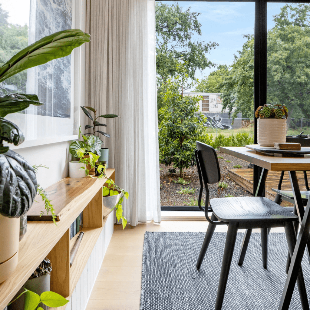 Image of table and shelves looking out onto a garden in a house designed with Powerhaus' energy efficiency consulting services.