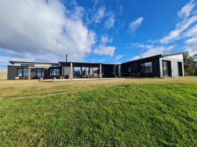 Image shows the front facade of the offgrid sustainable strawbale home at Harolds Crossing.